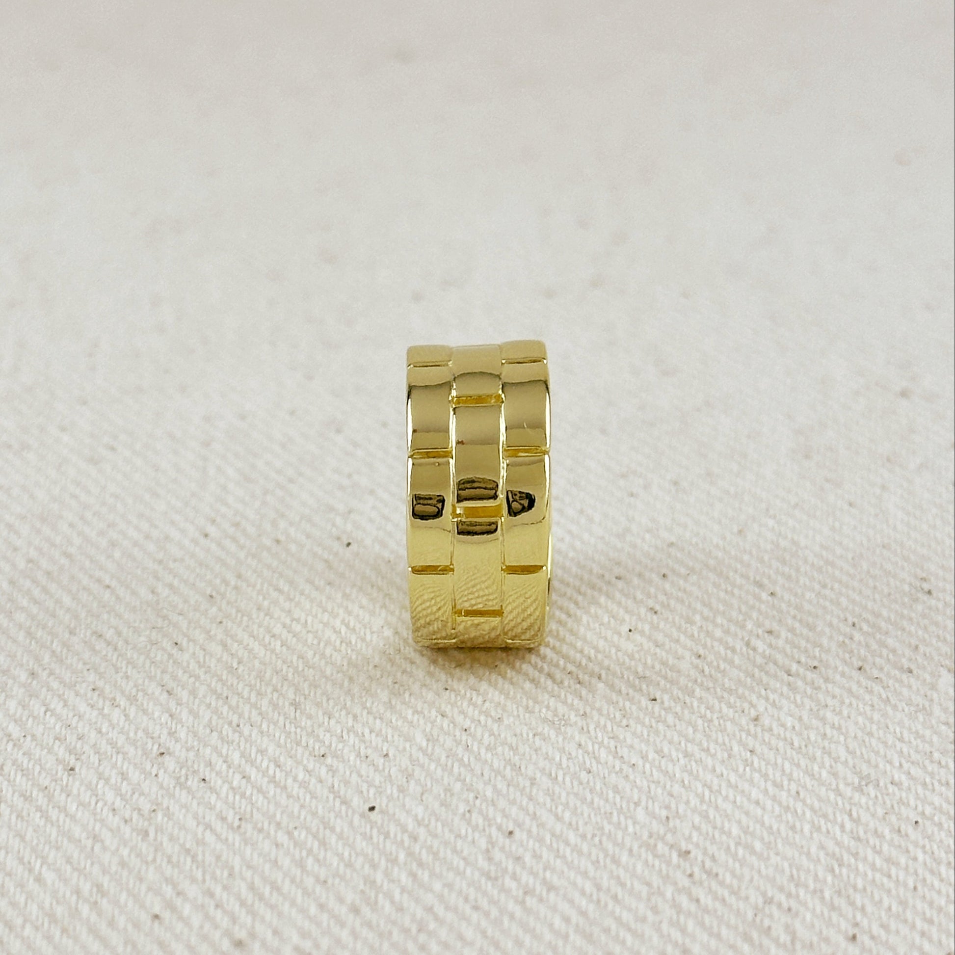 Gold ring on a textured beige background