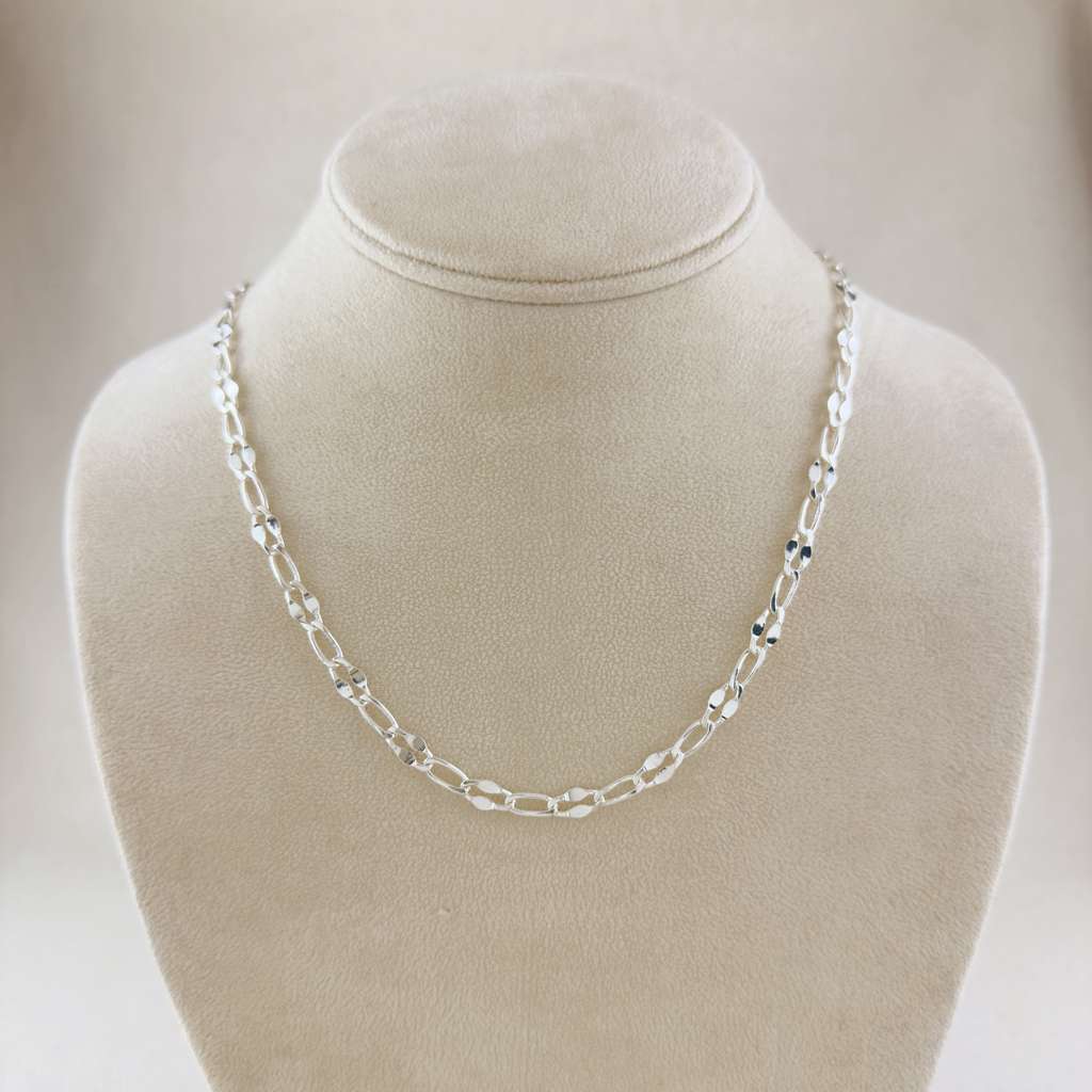 Silver chain necklace on a mannequin bust against a neutral background