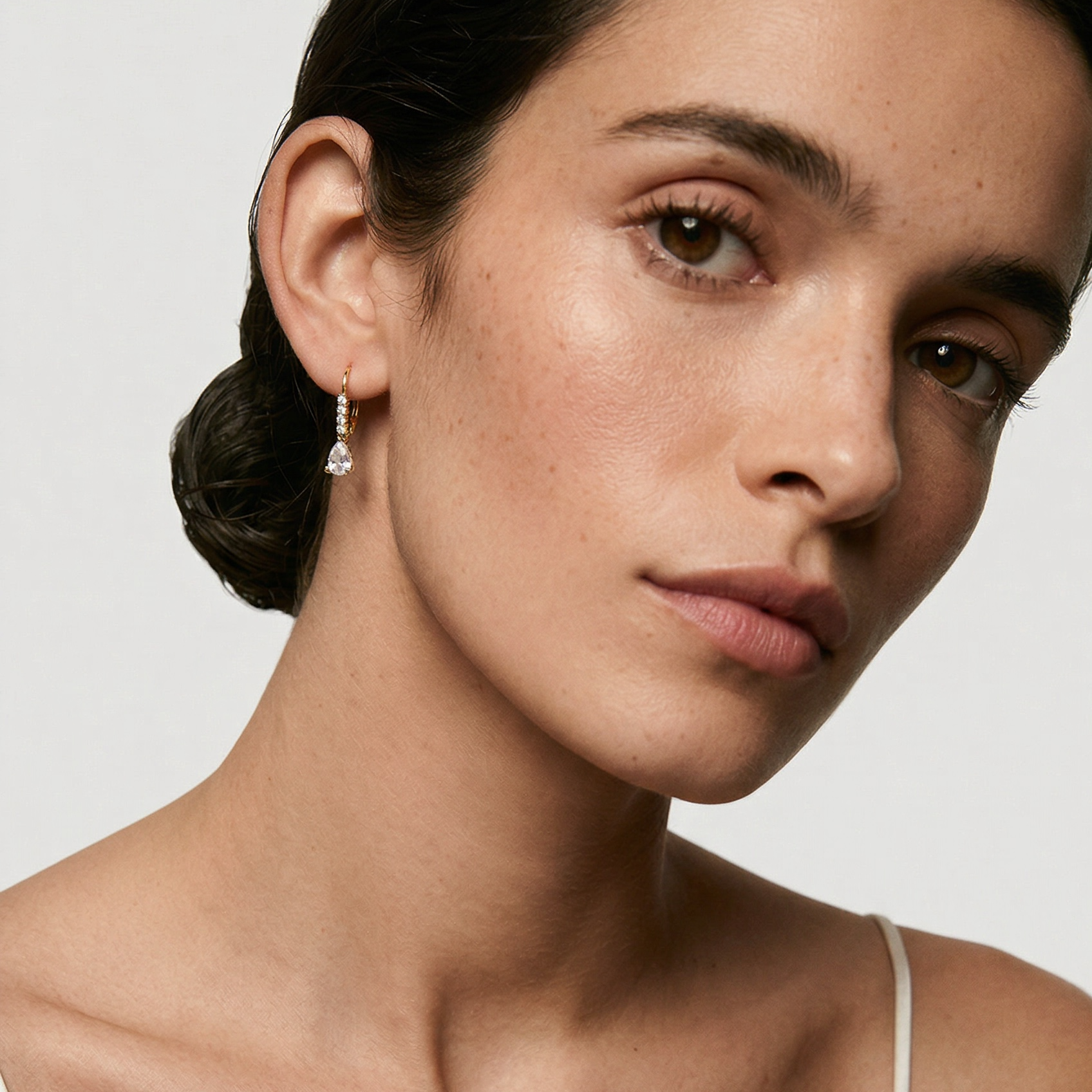 Woman wearing a white top with a plain background