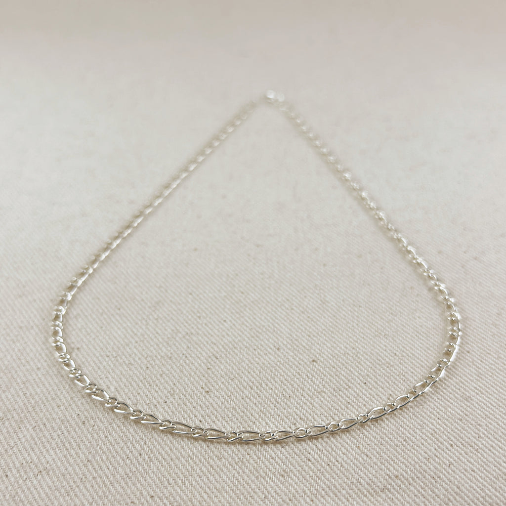 Silver chain necklace on a light beige fabric background