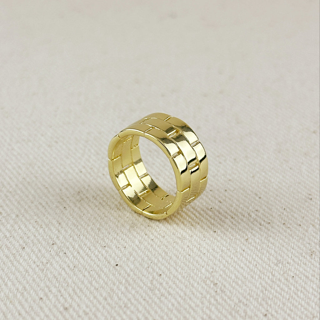 Gold ring with a textured pattern on a beige fabric background