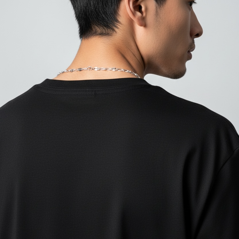 Person wearing a black t-shirt with a plain background