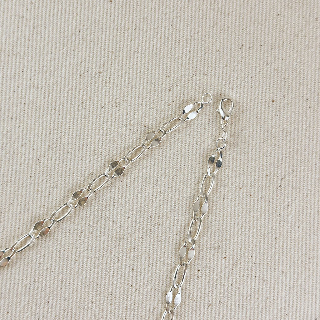 Silver chain necklace on a beige fabric background