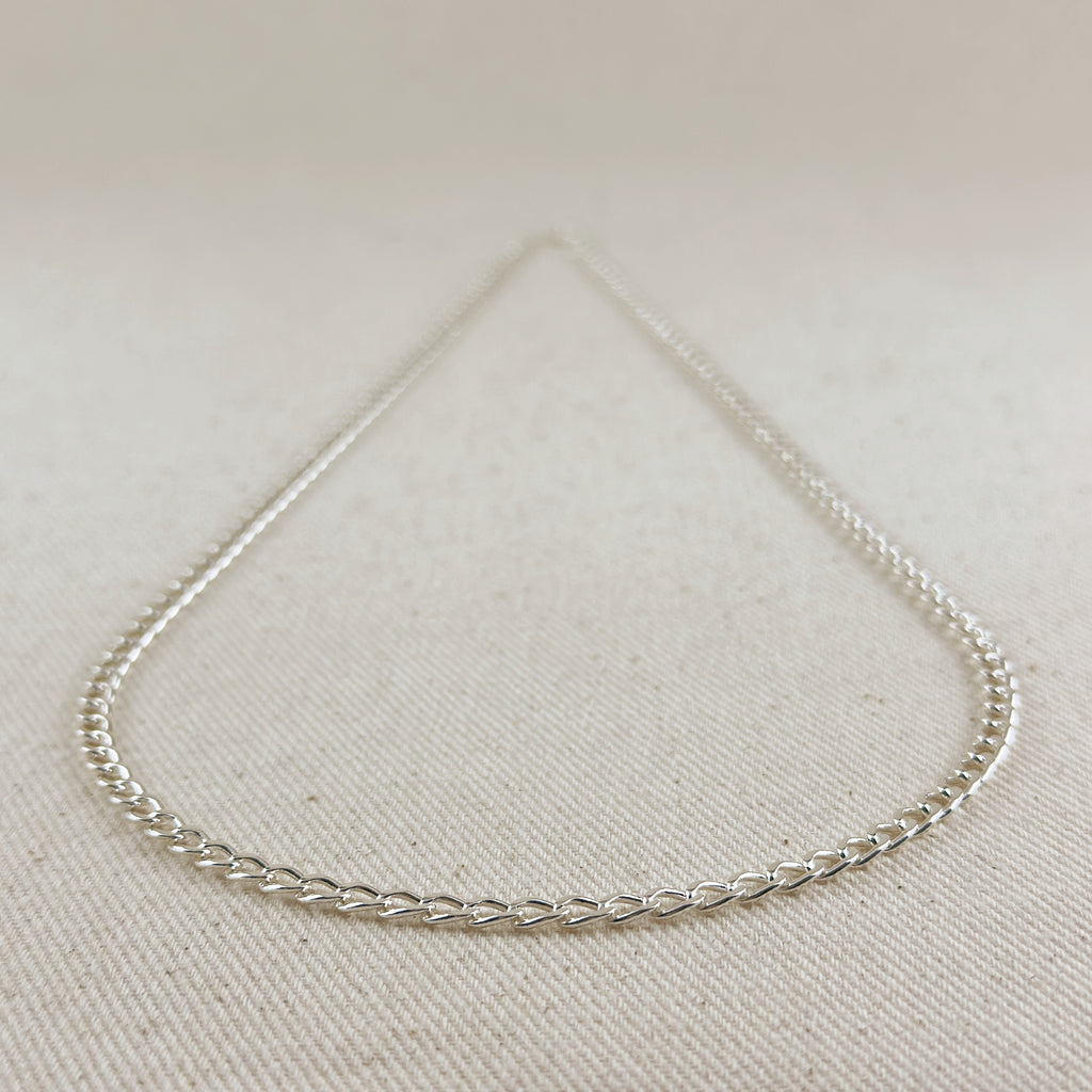 Silver chain necklace on a light beige fabric background