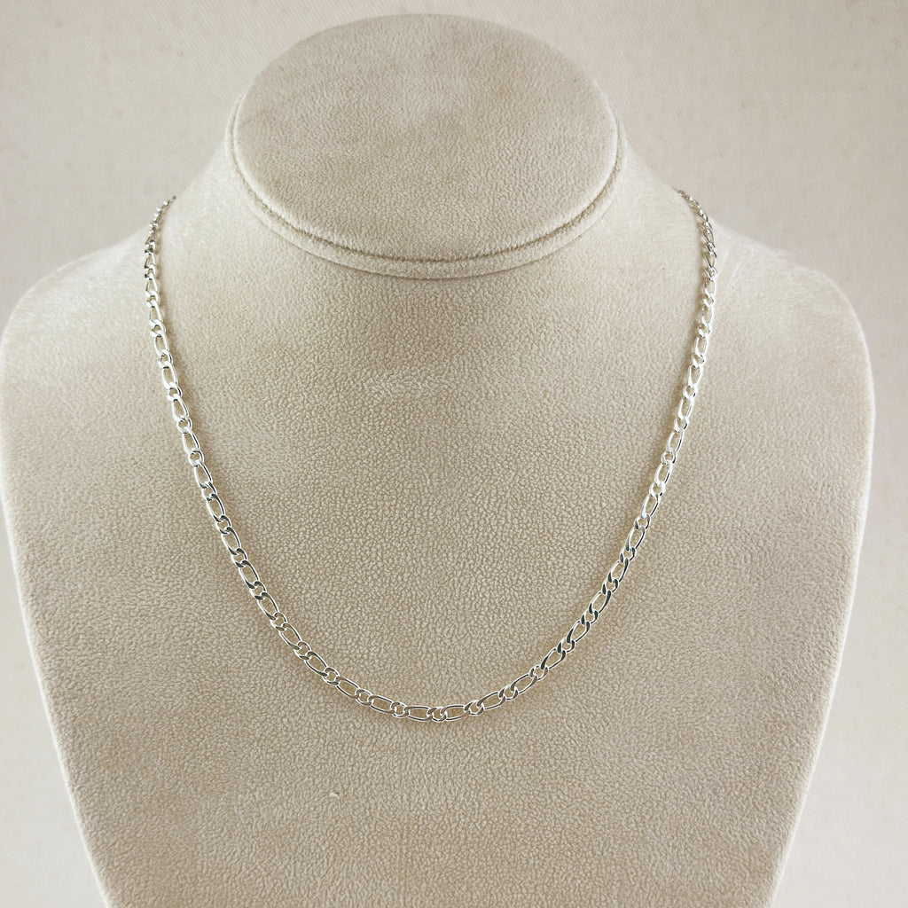 Silver chain necklace on a mannequin bust against a plain background