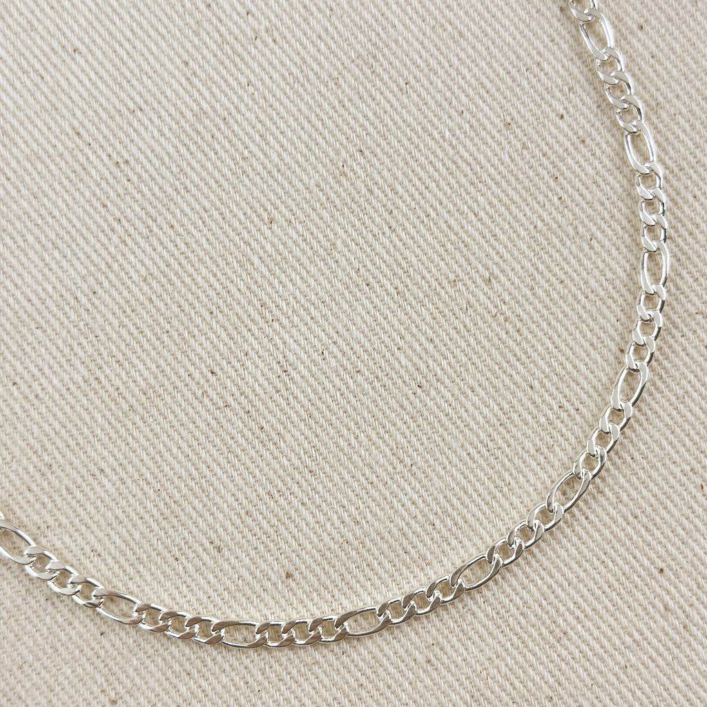 Silver chain necklace on a beige fabric background