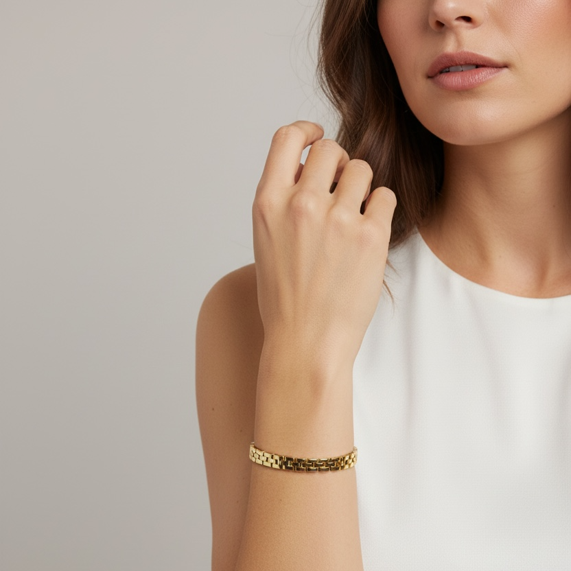Woman wearing a gold bracelet on a neutral background