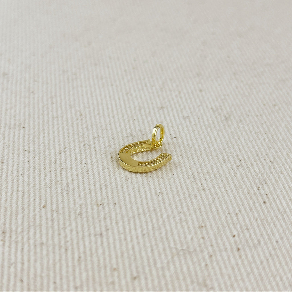 Gold pendant on a light beige fabric background