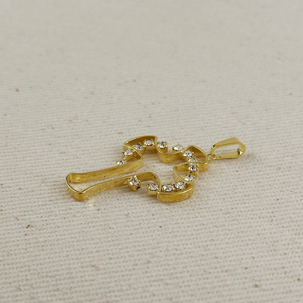 Gold pendant with embedded stones on a beige fabric background