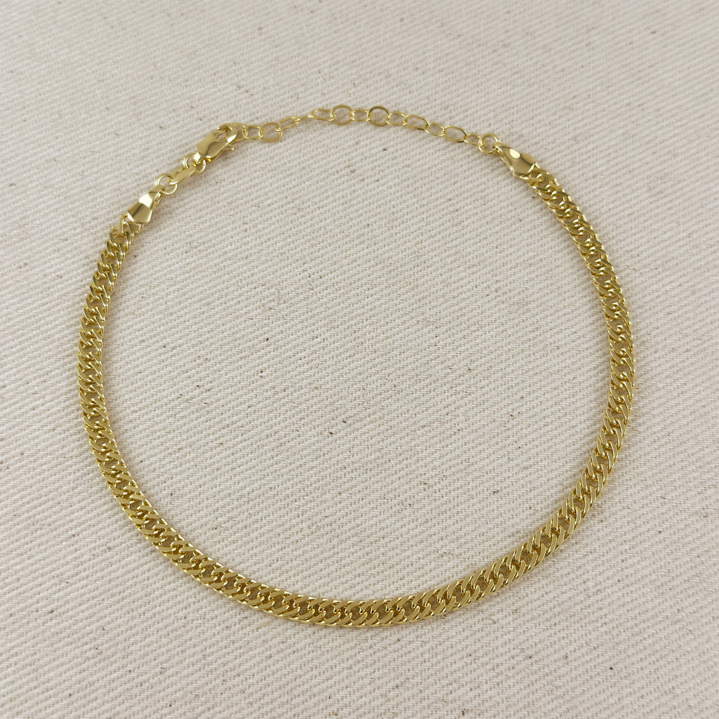 Gold chain necklace on a light beige fabric background