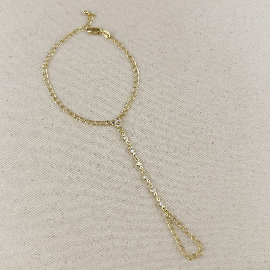 Gold chain bracelet on a beige fabric background