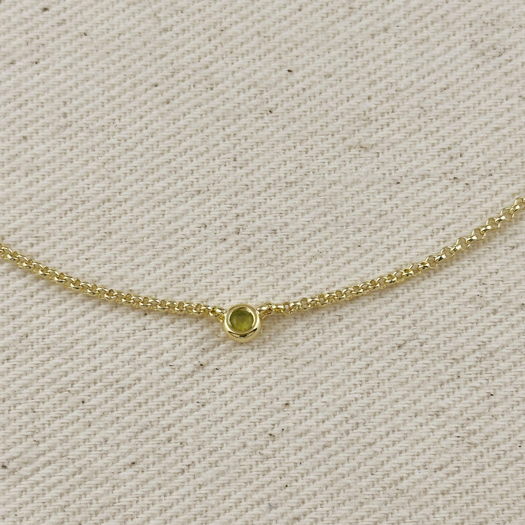 Close-up of 18K gold filled dainty necklace featuring a bezel setting, showcasing a cubic zirconia birthstone.