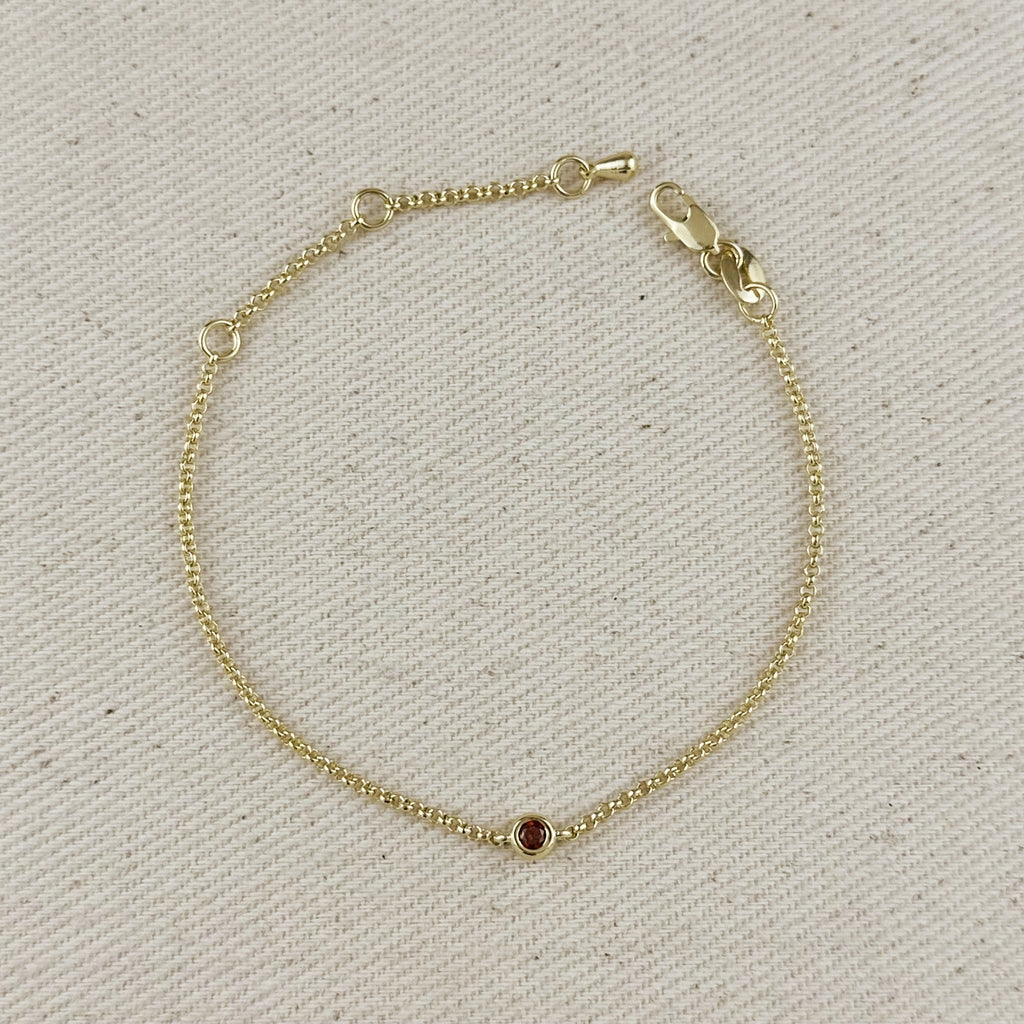 18K gold filled dainty bracelet featuring a bezel-set red cubic zirconia birthstone, perfect for personalized jewelry.