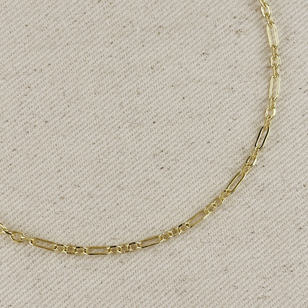 18K gold filled paperclip chain necklace with 3x1 alternated link pattern on textured background.