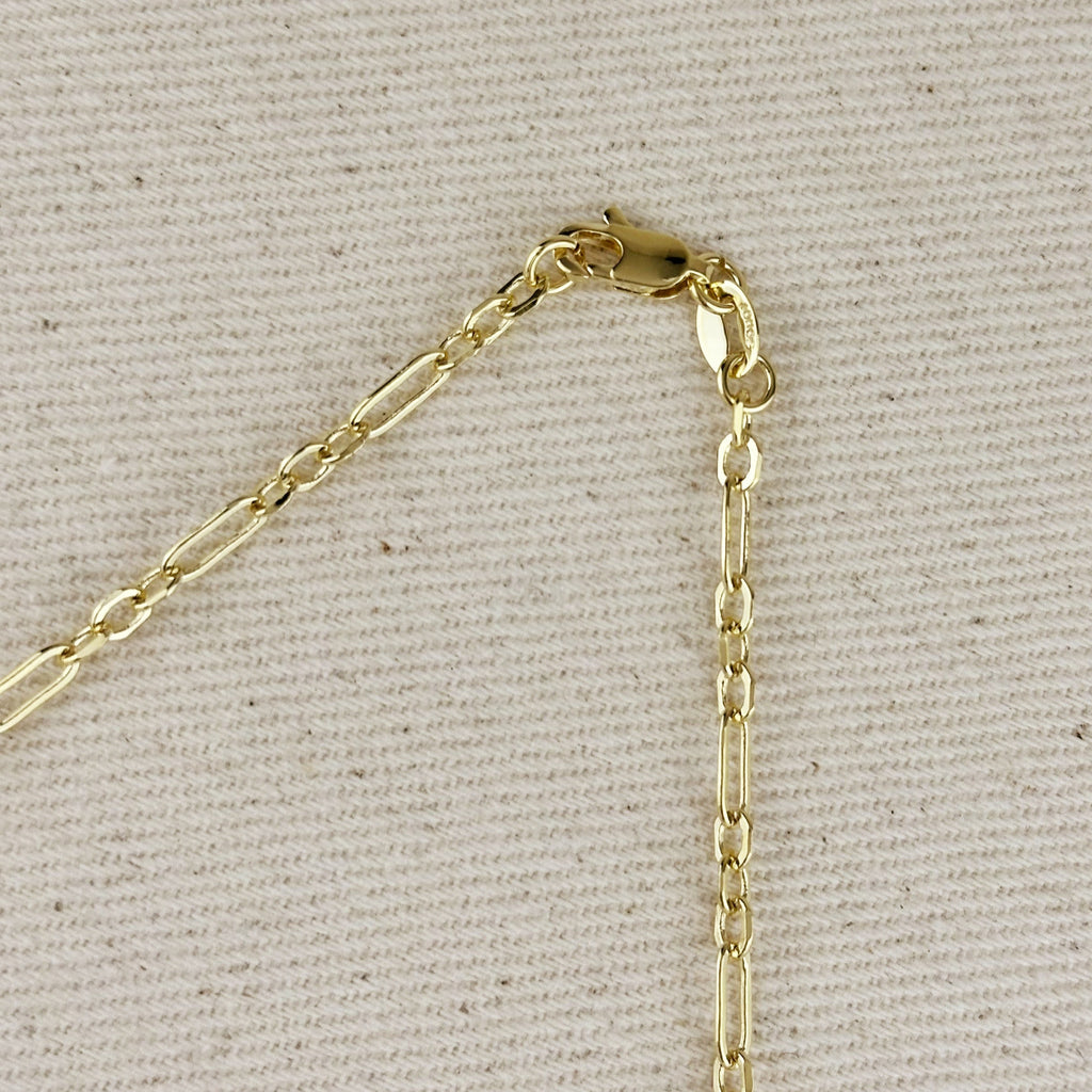 Gold chain clasp on a light gray fabric background