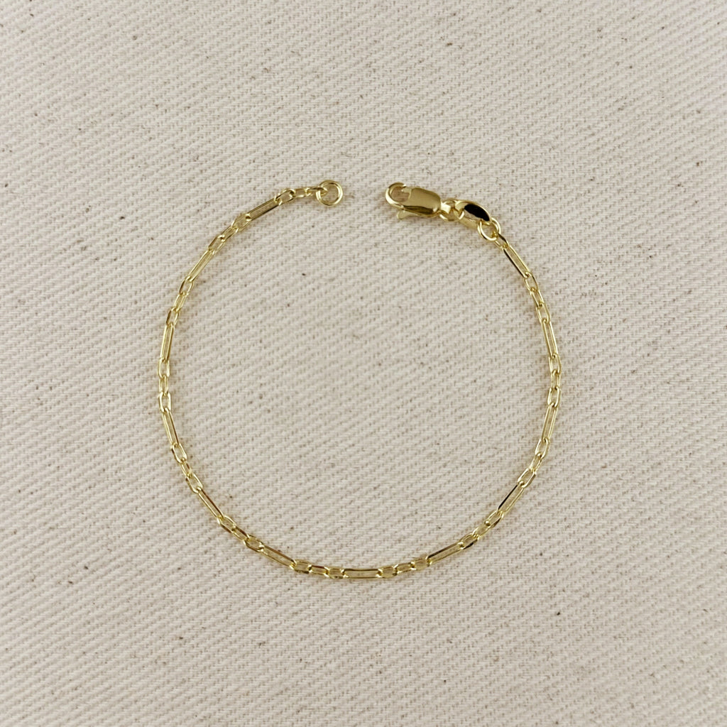 Gold bracelet on a beige fabric background