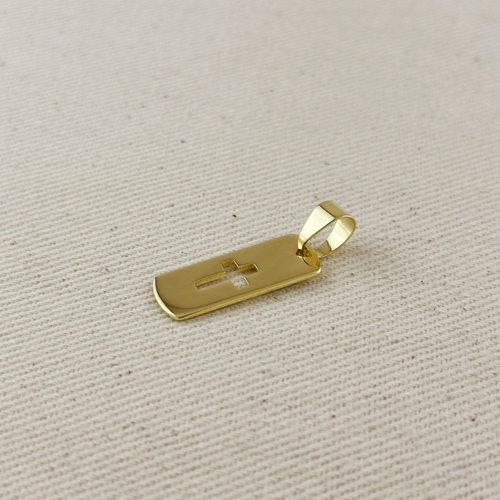 Gold pendant with a cross on a beige fabric background