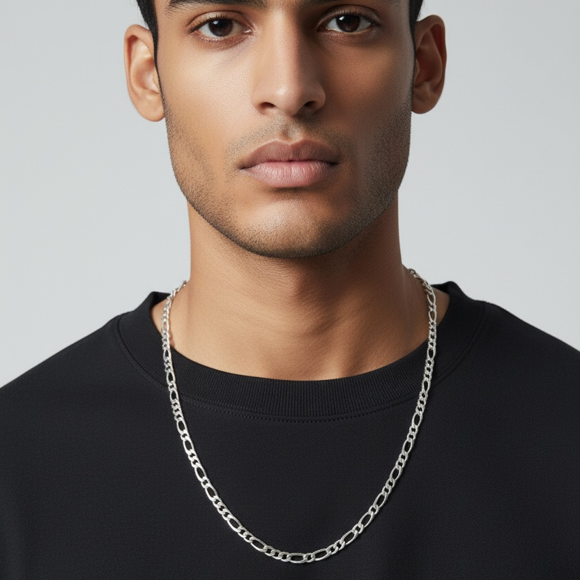 Man wearing a black shirt and silver chain necklace against a plain background