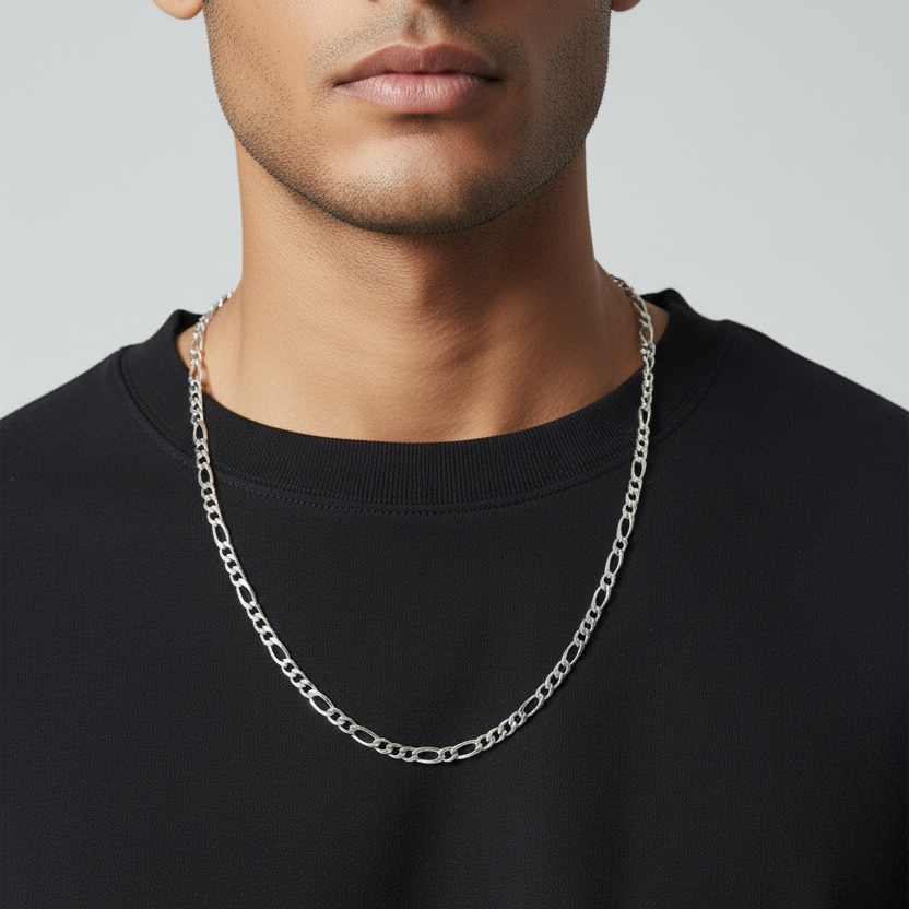Man wearing a black shirt with a silver chain necklace against a neutral background