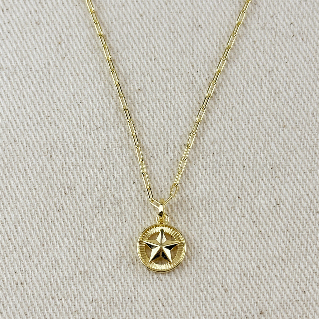 Gold necklace with a star pendant on a beige fabric background