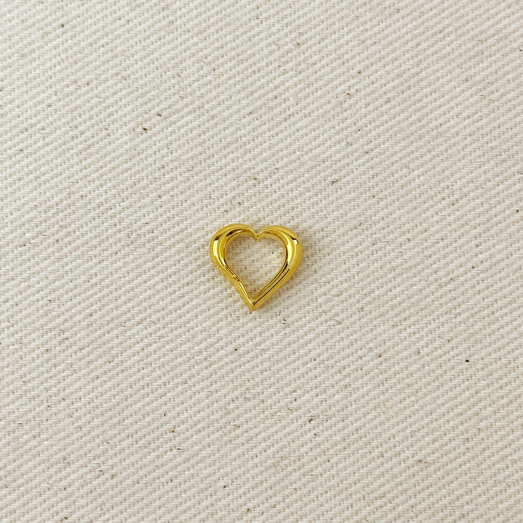 Gold heart-shaped charm on a beige fabric background