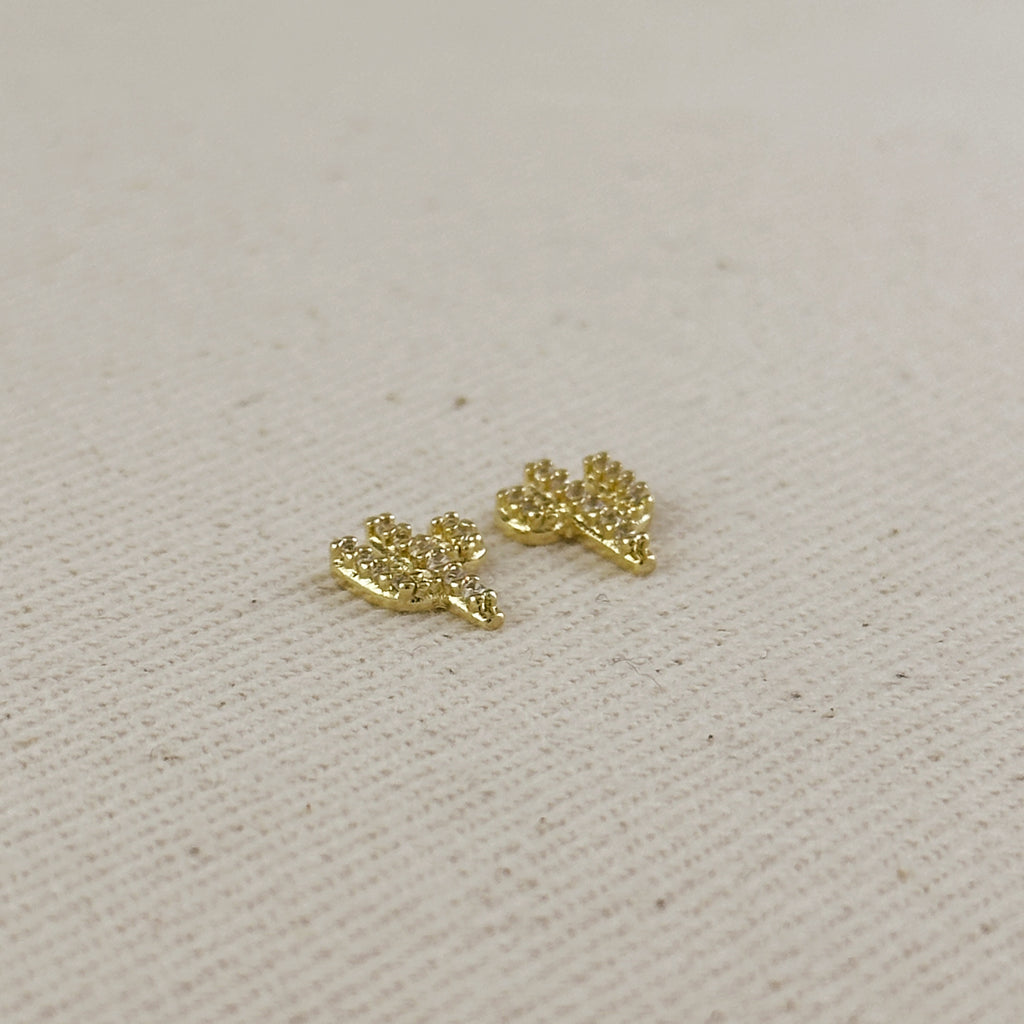 Pair of gold cactus earrings on a light fabric background