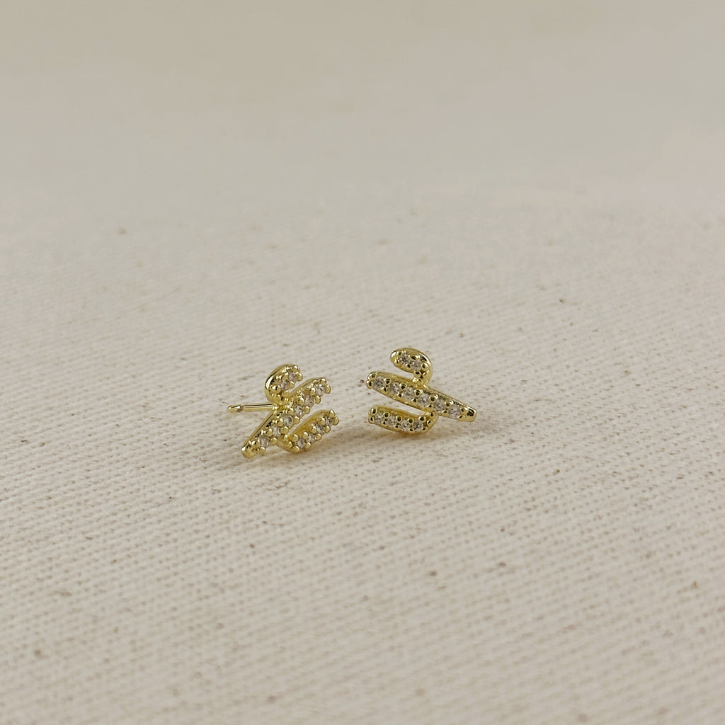 Gold cactus earrings on a beige fabric background