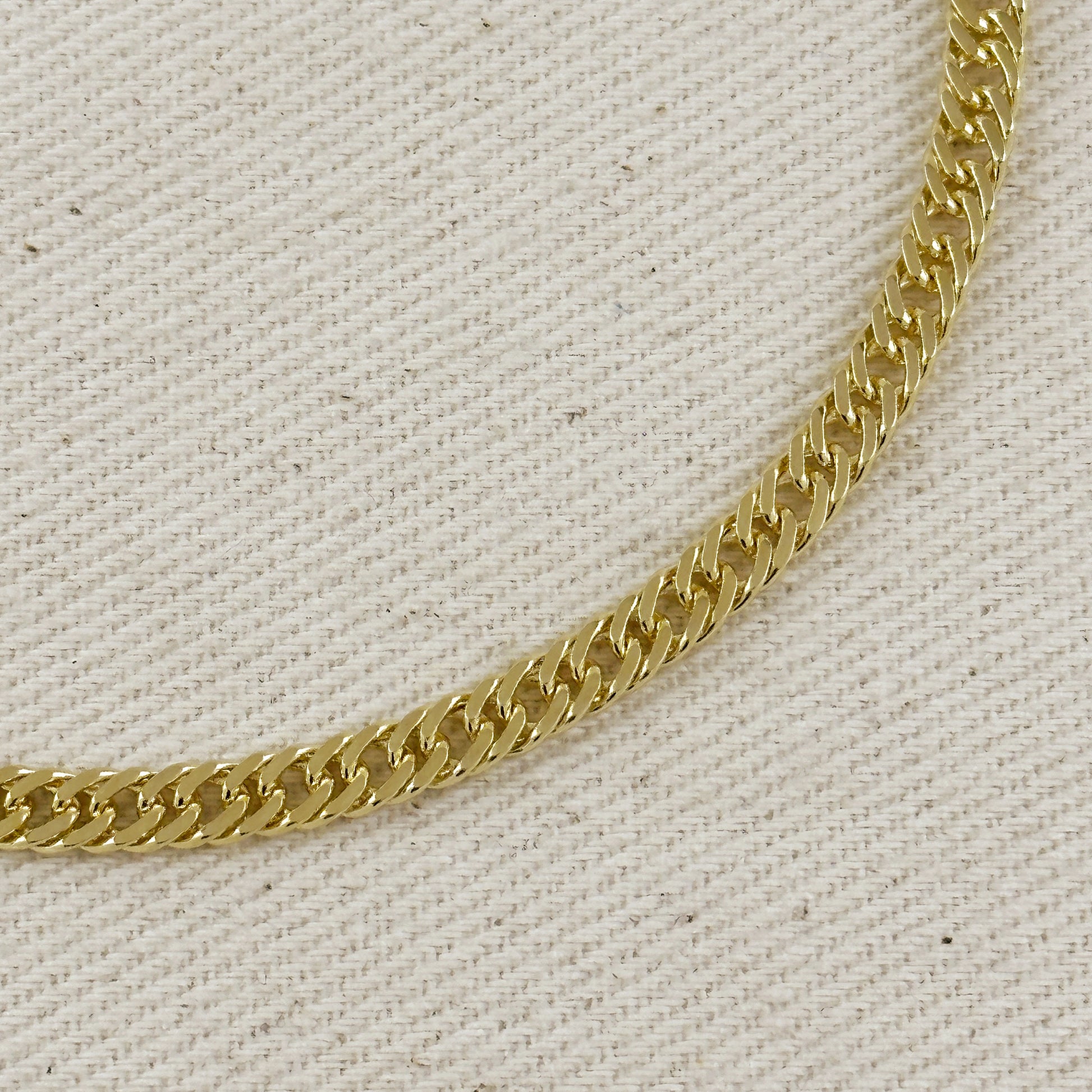 Gold chain on a textured beige background