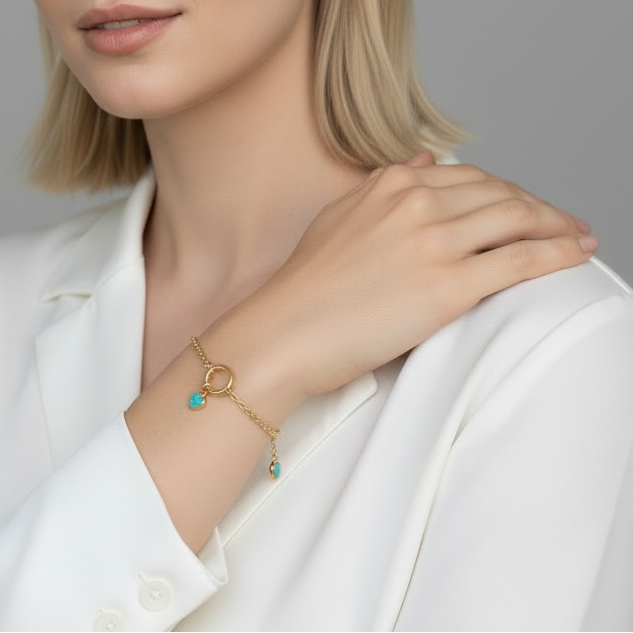 Woman wearing gold jewelry with a gray background