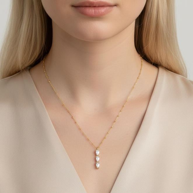 Woman wearing a delicate necklace with a plain background