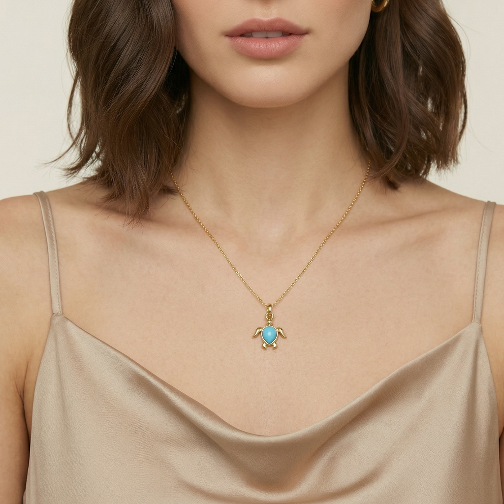 Woman wearing a gold necklace with a turtle pendant on a beige background