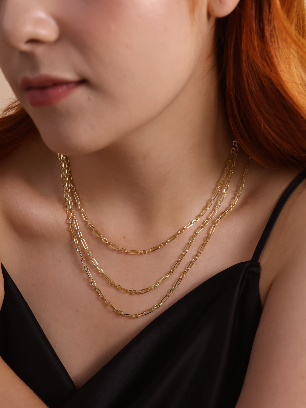 Model wearing a layered 18K gold filled paperclip necklace showcasing a modern, minimalist design.