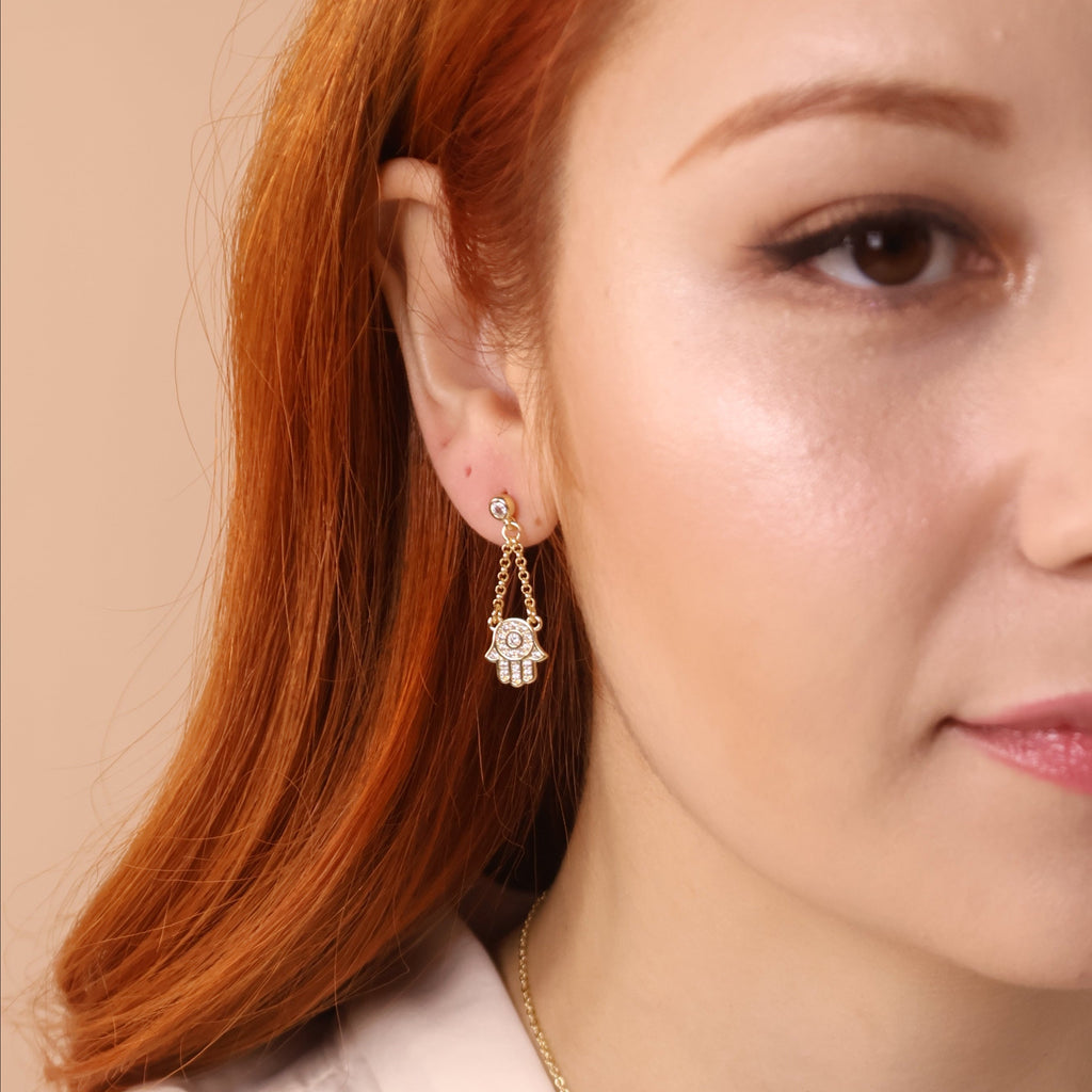 Close-up of a woman wearing gold jewelry on a beige background